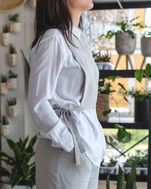 Plastron gris pâle en lin agencé à une chemise blanche et le Bermuda gris pâle. 